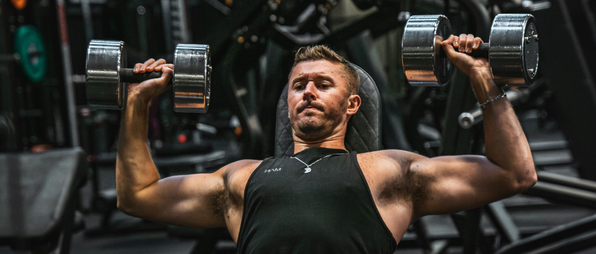 Athlete training with dumbbells in the gym